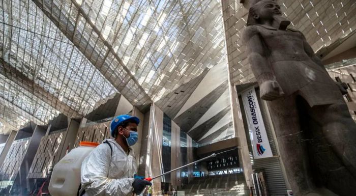 Workers spray disinfectant inside the new museum to combat the spread of Covid-19.