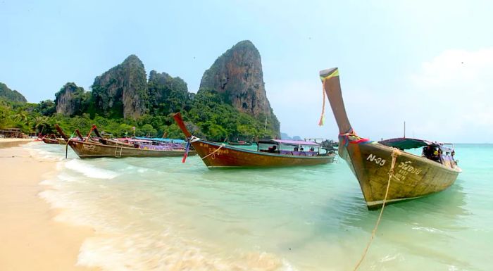 A line of long-tail boats docked along Railay West