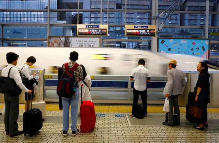 Travelers getting ready to board a Shinkansen bullet train in Kyoto, Japan.