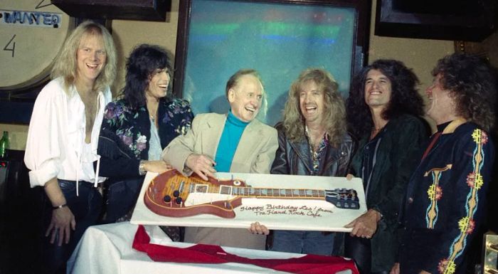 Aerosmith celebrated Les Paul's birthday at the Hard Rock in New York City by presenting him with a guitar-shaped cake.