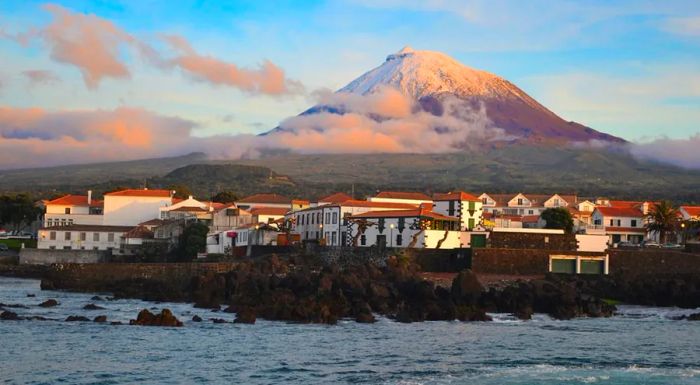 Portugal's tallest mountain isn't located on the mainland, but rather on the Azores' Montanha do Pico, an active volcano on Pico Island. The charming village of Madalena is visible below at sunset.