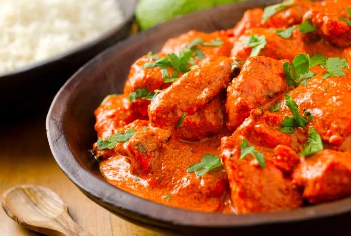 Butter chicken curry served with basmati rice and fresh limes.