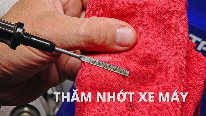 Dùng que thăm nhớt để kiểm tra mức dầu nhớt trong xe