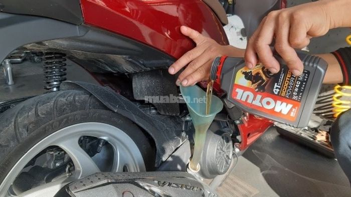 Đặt phễu vào lỗ châm nhớt rồi bắt đầu đổ nhớt mới vào