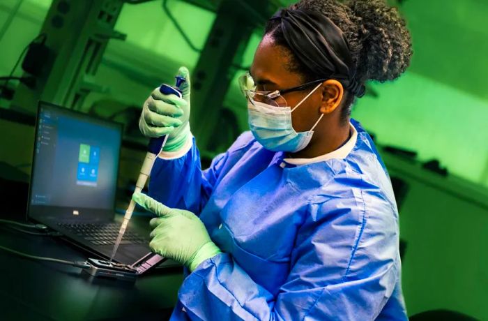 A public health scientist from the CDC's Enteric Diseases Laboratory Branch sets up a portable sequencing instrument for whole genome sequencing, which provides detailed genetic data on the pathogens responsible for illnesses.