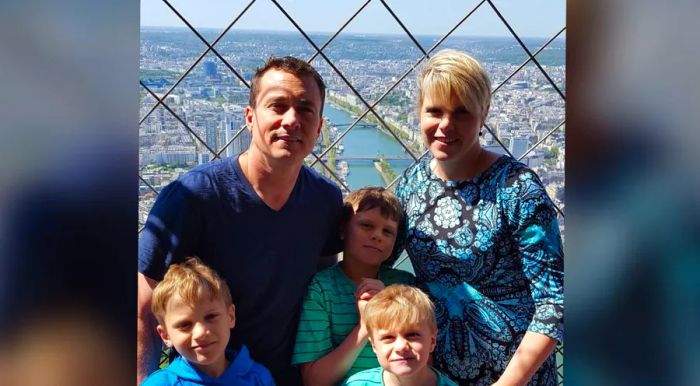 The couple took a photo at the summit of the Eiffel Tower, with their three sons by their side.