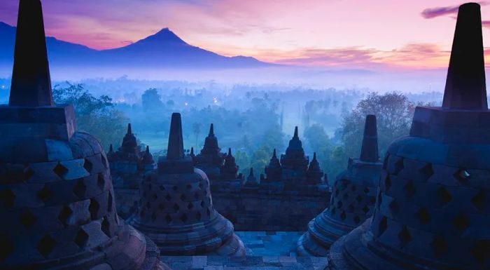 Sunrise at Borobudur is a favorite time for visitors to witness the stunning views of the temple's statues and the surrounding volcanoes from the summit.