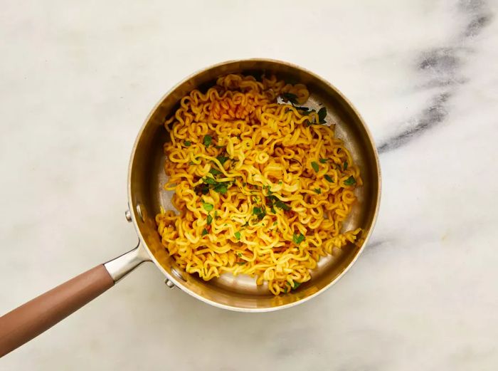 After draining the water, stir in the seasoning packet and parsley into the ramen noodles.