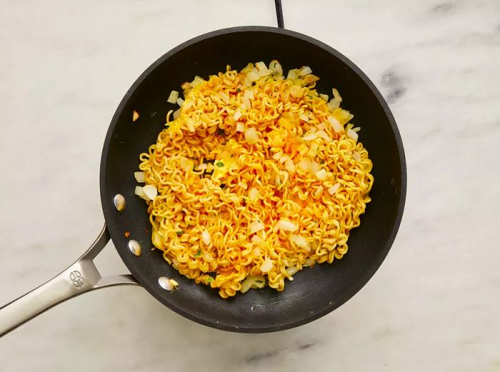 The egg mixture is poured into the skillet with the noodle mixture.