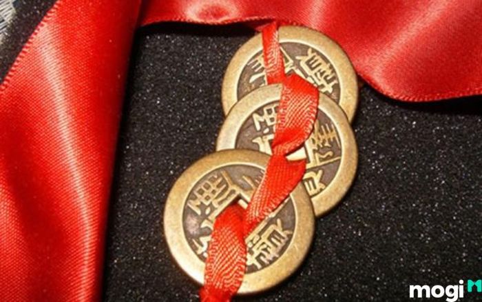 Đặt ba đồng xu xâu bằng chỉ đỏ vào bình hút lộc