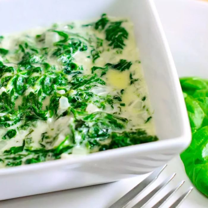 Cheesy Spinach Gratin in a white serving dish