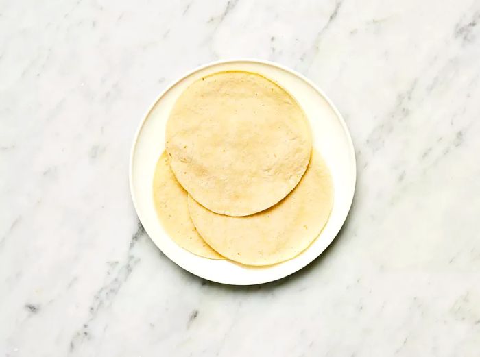 Corn tortillas arranged on a white plate