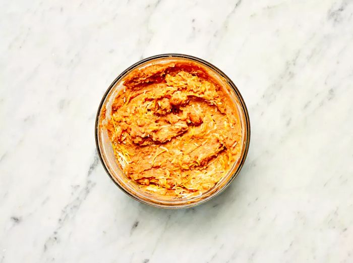 Refried beans and cheese mixture in a glass bowl