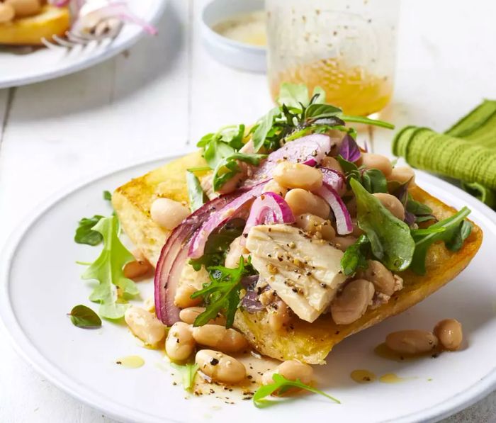 Toasted bread topped with cannellini beans, red onions, arugula, and tuna.