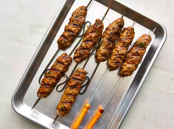 View from above of grilled kofta kebabs resting on a baking sheet