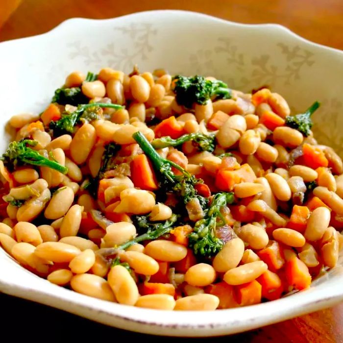 A vibrant Maple Cannellini Bean Salad featuring Baby Broccoli and Butternut Squash, served in a pristine white dish.