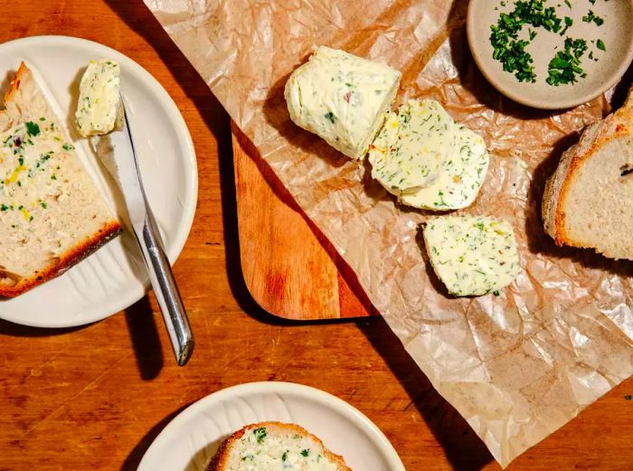 Butter on serving dish, accompanied by buttered bread on a plate