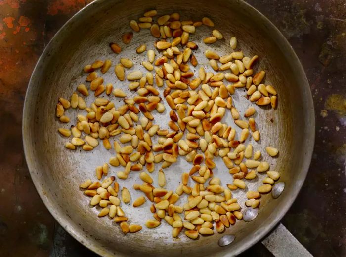 Toasting pine nuts in a skillet, overhead view