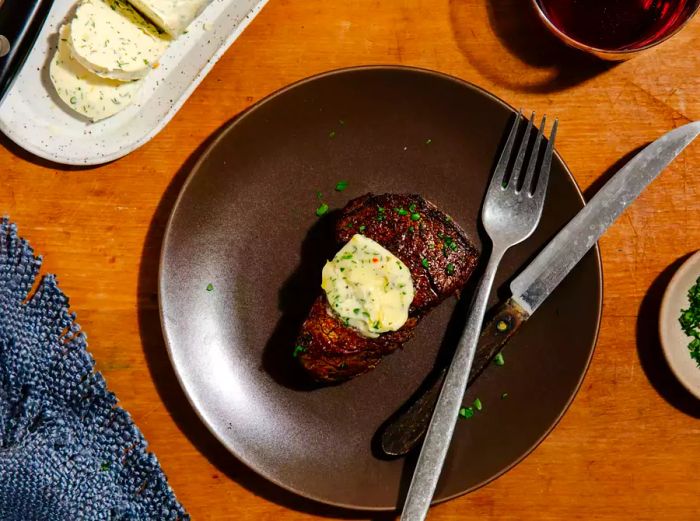 Ree Drummond’s Cowboy Butter on a steak served on a brown plate