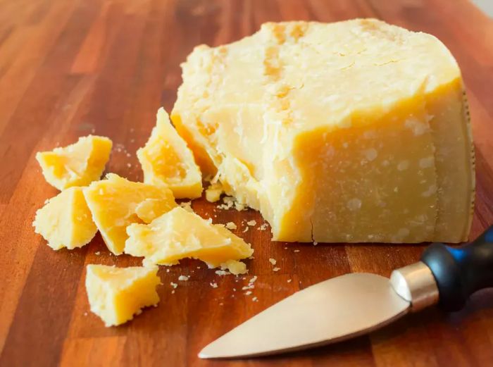 Pieces of Parmesan cheese on a wooden cutting board