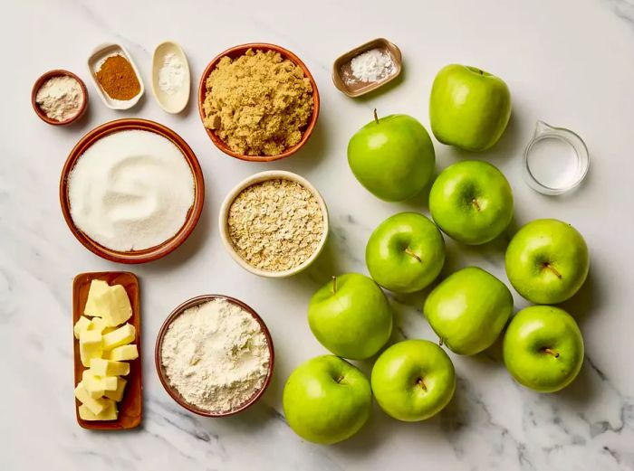 A top-down view of the ingredients needed to make apple crisp, all measured out and ready to go.