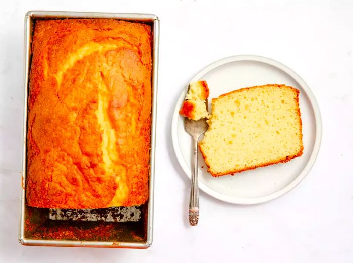 A sour cream loaf cake with a slice cut out.