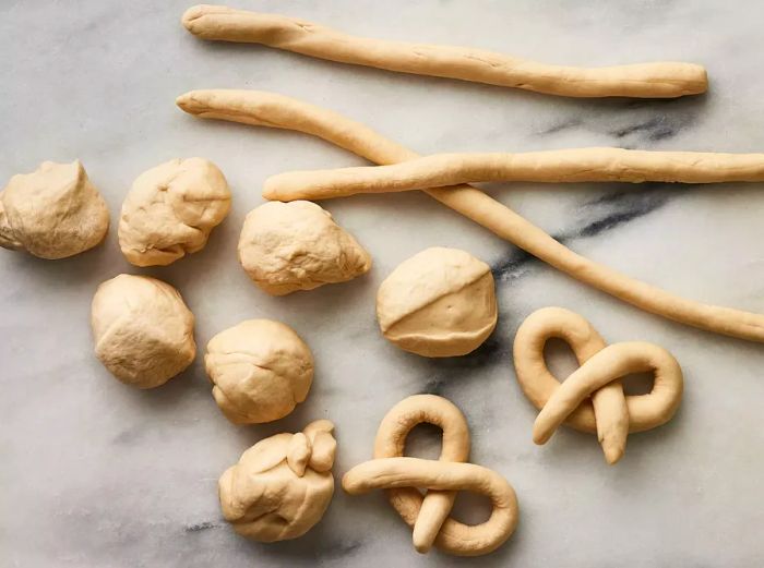 Dough pieces rolled into ropes and twisted into perfect pretzel shapes.