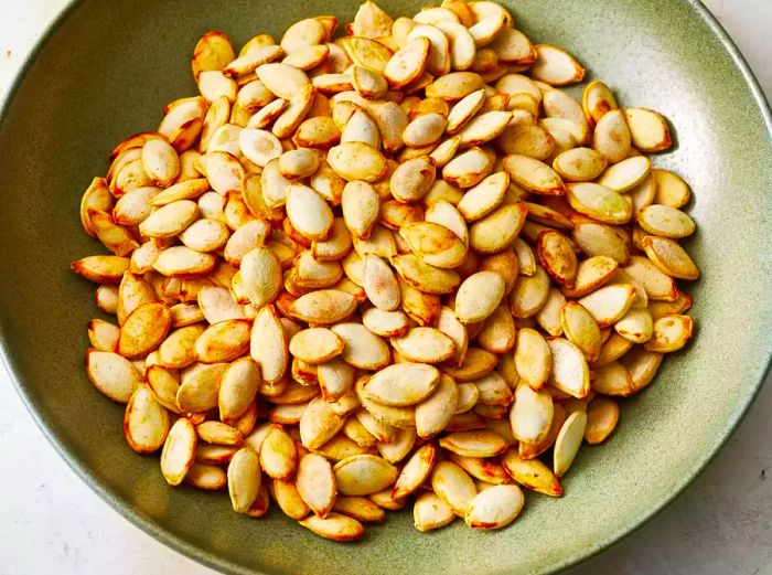 A close-up shot of crispy roasted pumpkin seeds served in a bowl.