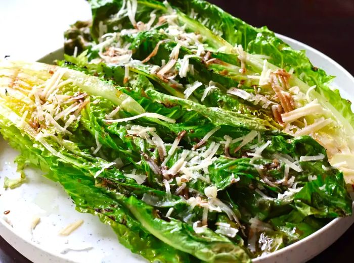 Grilled romaine topped with freshly grated Parmesan cheese