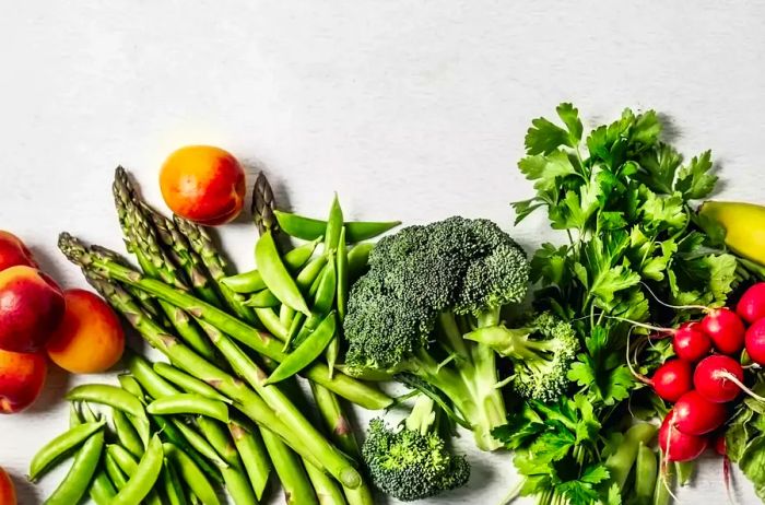 A variety of fresh fruits and vegetables on a white background.