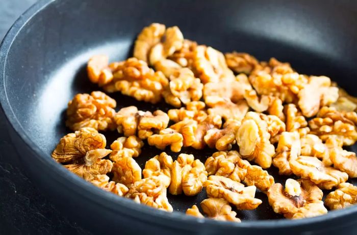 Walnuts toasting in a frying pan