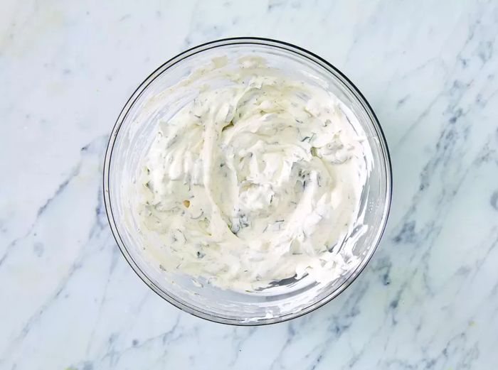 A top-down view of the sour cream mixture resting in a glass bowl.