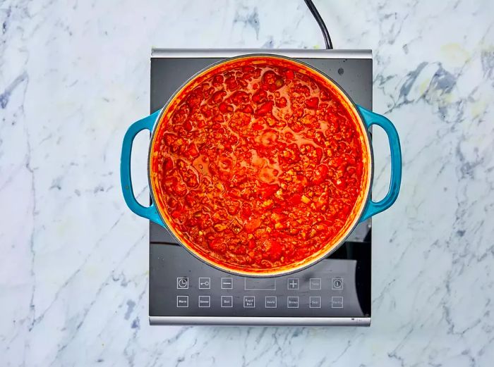 A bird's-eye view of chili simmering in a pot.