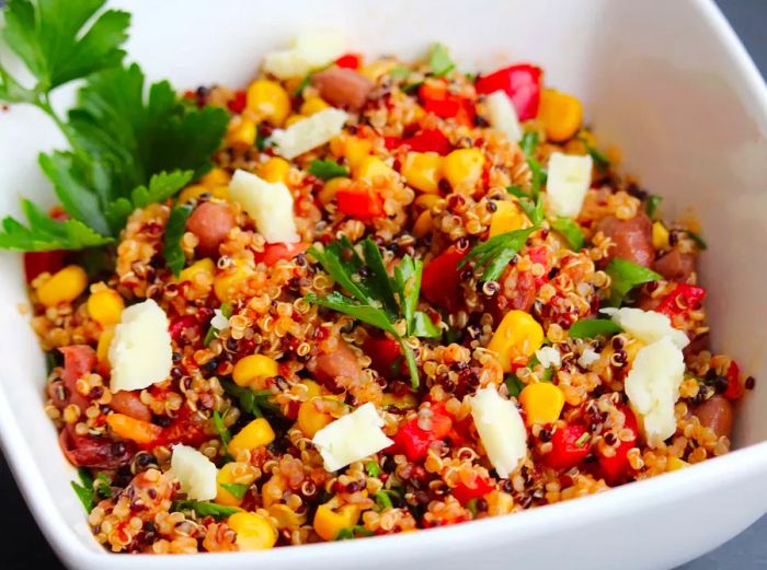 Close-up of a Southwestern Quinoa Salad with corn and fresh herbs served in a white bowl