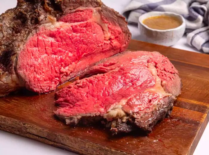 Slices of prime rib roast on a wooden cutting board.