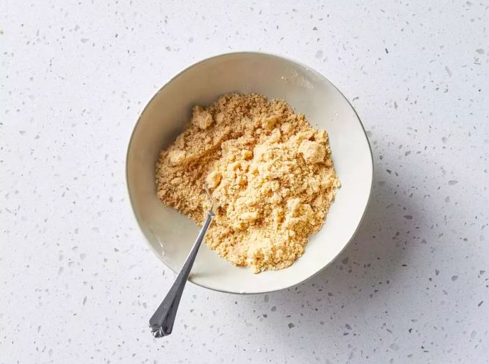 A small bowl filled with sweet brown sugar crumbs.