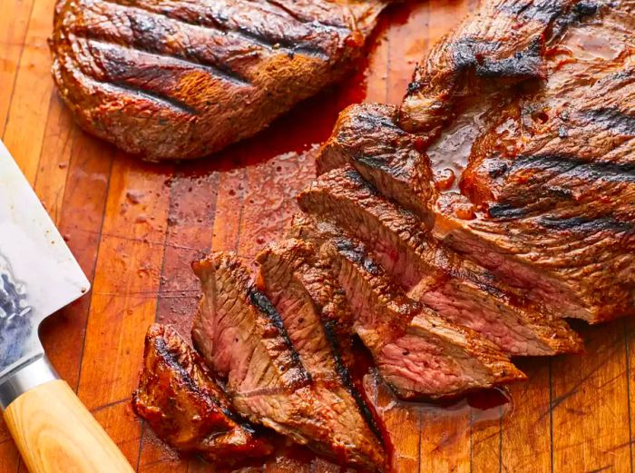 Sliced steak resting on a wooden cutting board