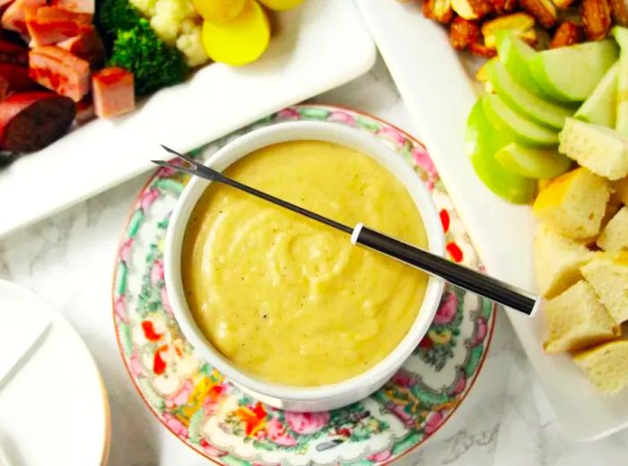 A plate of creamy cheese fondue, served with a floral design