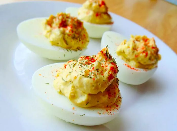 Close-up of Deviled Eggs with Horseradish, sprinkled with paprika on a white plate