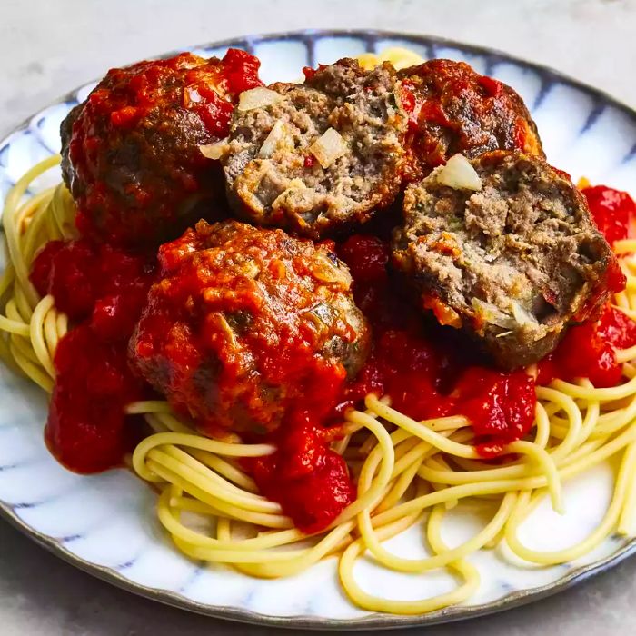 A close-up view of a plate of spaghetti topped with meatballs.