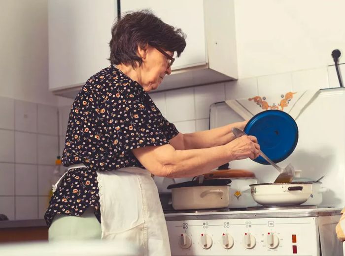 An energetic senior woman from Eastern Europe lovingly preparing a homemade meal for her family in a cozy, traditional kitchen. A true passion for cooking shines through.