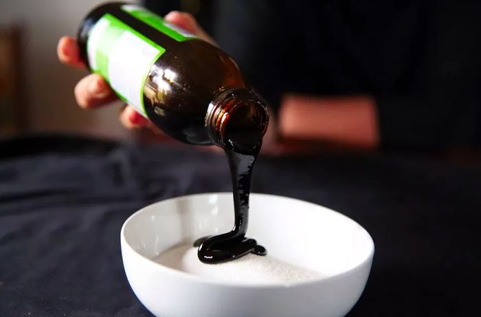 Pouring molasses into a bowl of sugar