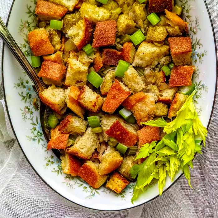 Bird's-eye view of Bread and Celery Stuffing served on a platter with a spoon