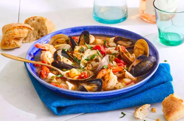 A bowl of homemade cioppino served with a side of bread.