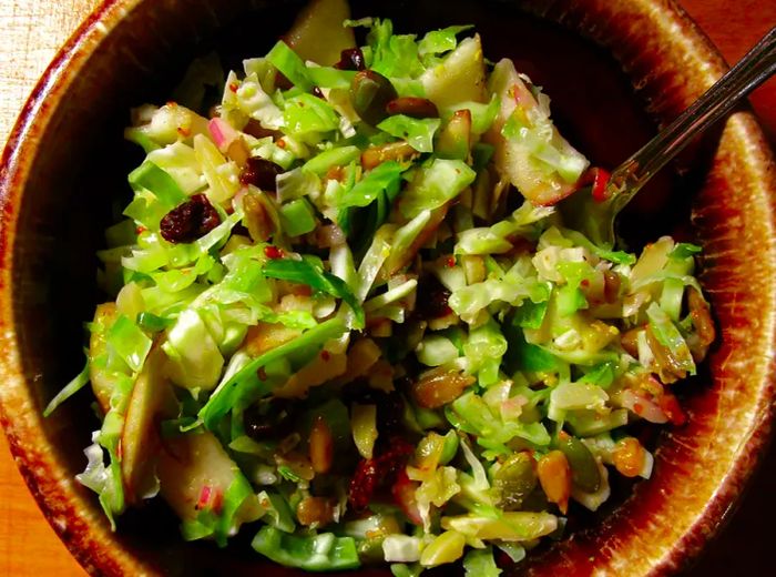 overhead shot of a brown ceramic bowl filled with salad