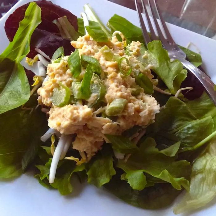 A plate of fresh greens paired with a mock tuna salad made from chickpeas