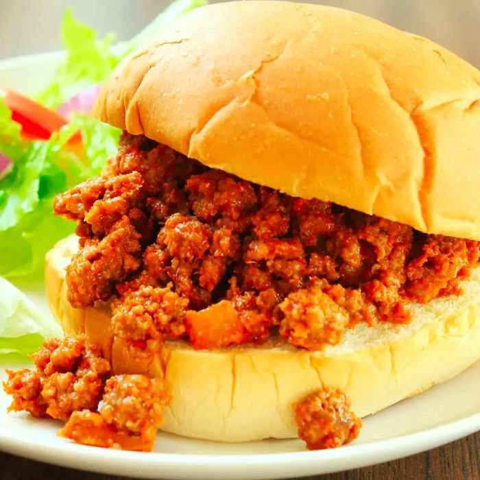 A close-up shot of a delicious, messy sloppy joe sandwich, served hot and ready to enjoy.