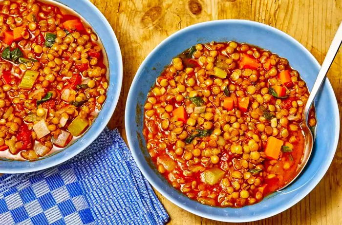 An overhead shot of two bowls of hearty lentil soup