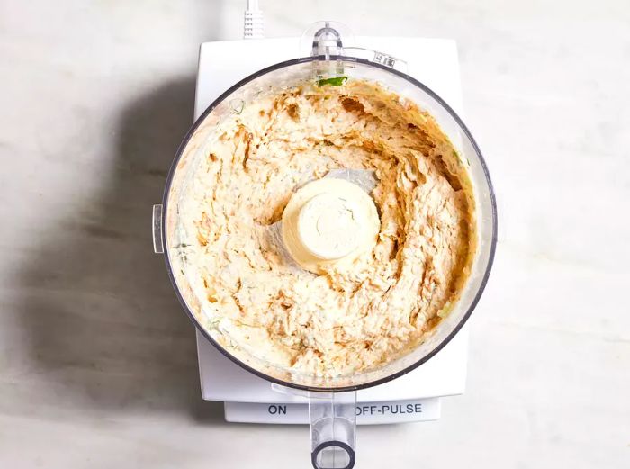 Bird's-eye view of the salmon spread in a food processor, ready for blending.