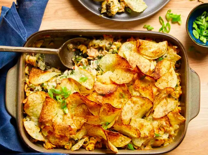 A top-down view of a tuna noodle casserole crowned with crispy, golden-brown potato chips.